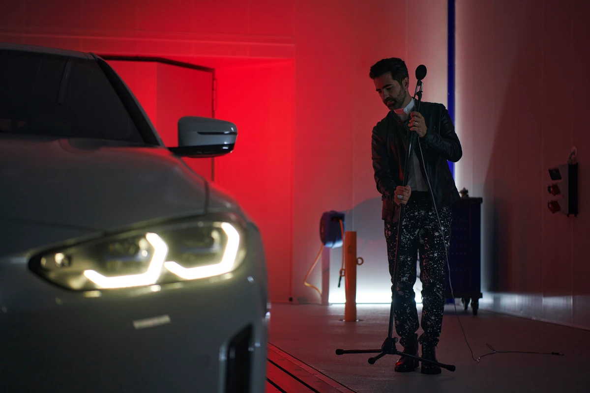 Sound technician preparing a microphone next to a BMW for an acoustic recording